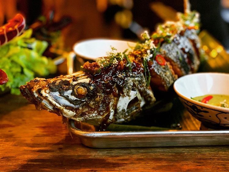 Pescado preparado por Mano Negra, servido con hierbas y acompañamientos